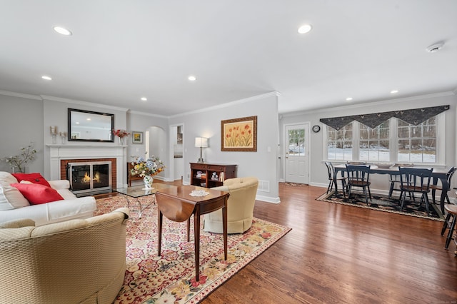 living area with recessed lighting, a fireplace, baseboards, ornamental molding, and dark wood finished floors