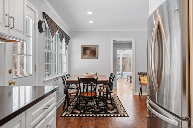 dining area with dark wood-style floors, baseboards, ornamental molding, and recessed lighting