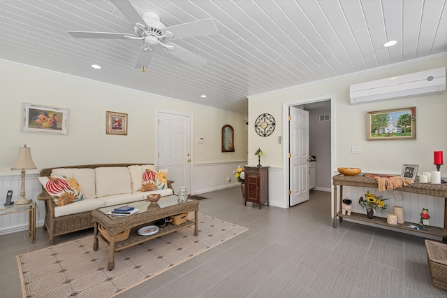 living area featuring wainscoting, crown molding, and a wall mounted AC