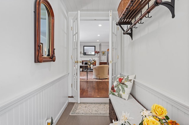 interior space featuring ornamental molding, recessed lighting, and a wainscoted wall