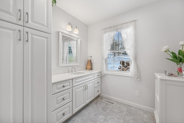 bathroom with baseboards, visible vents, and vanity