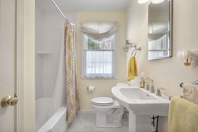 bathroom with toilet, shower / tub combo, baseboards, and tile patterned floors