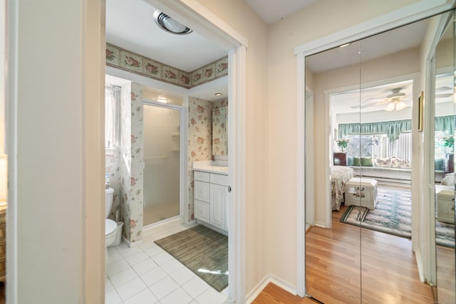 full bath featuring tile patterned floors, a stall shower, toilet, baseboards, and vanity
