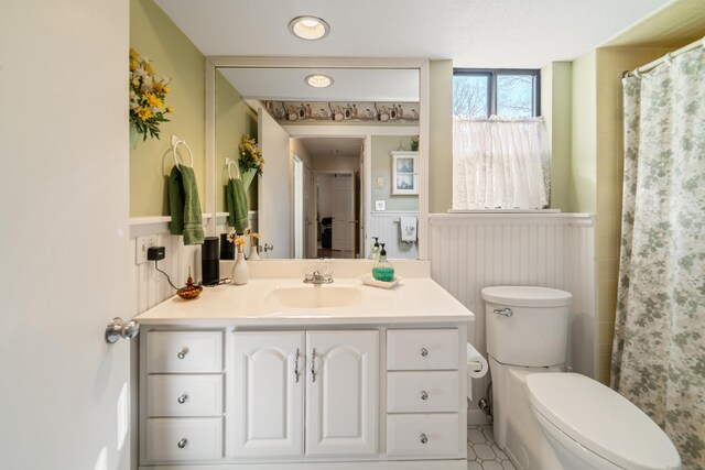 full bathroom with vanity, toilet, a wainscoted wall, and a shower with shower curtain