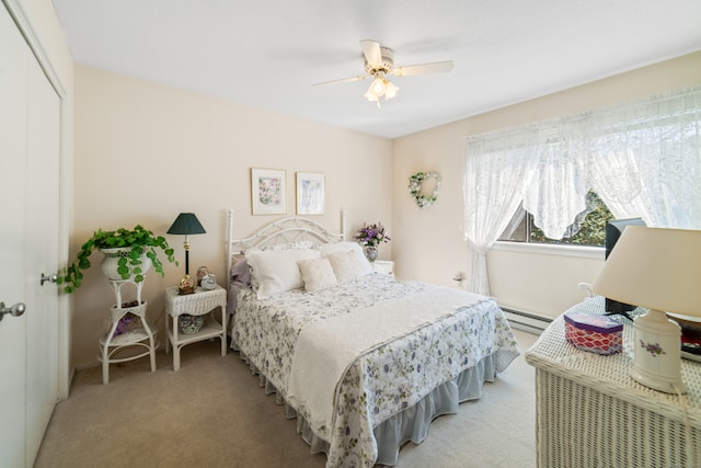 bedroom featuring baseboard heating, ceiling fan, light carpet, and a closet