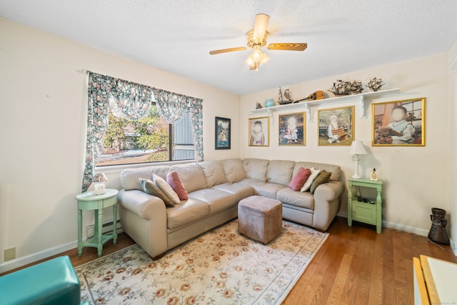 living room with hardwood / wood-style flooring, baseboards, a textured ceiling, and ceiling fan