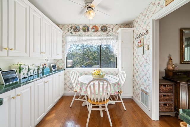 dining room with visible vents, wallpapered walls, a ceiling fan, and baseboards