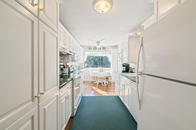 kitchen with white cabinetry, under cabinet range hood, dark wood-style floors, and white appliances