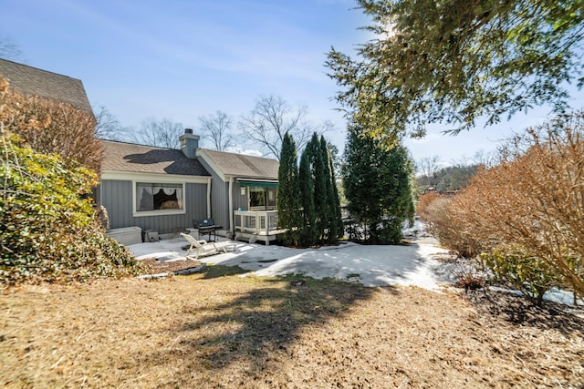 back of property featuring a chimney, a patio, and board and batten siding