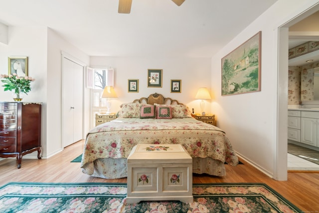 bedroom with connected bathroom, ceiling fan, baseboards, and light wood-type flooring