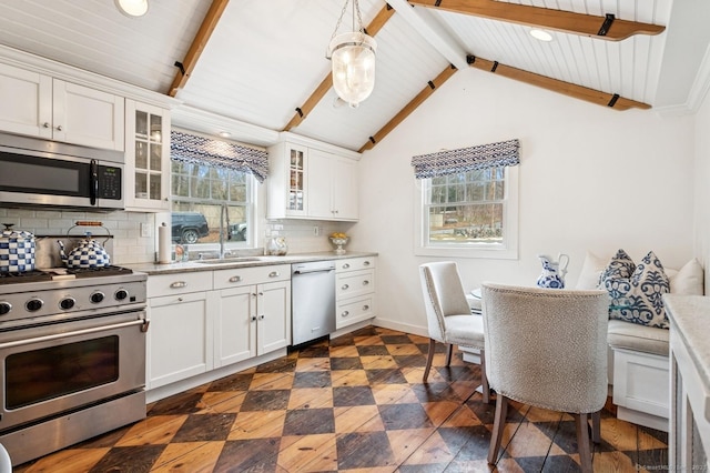 kitchen with appliances with stainless steel finishes, decorative backsplash, glass insert cabinets, and white cabinetry