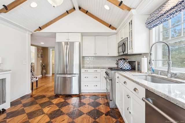 kitchen with stainless steel appliances, a sink, white cabinets, decorative backsplash, and glass insert cabinets