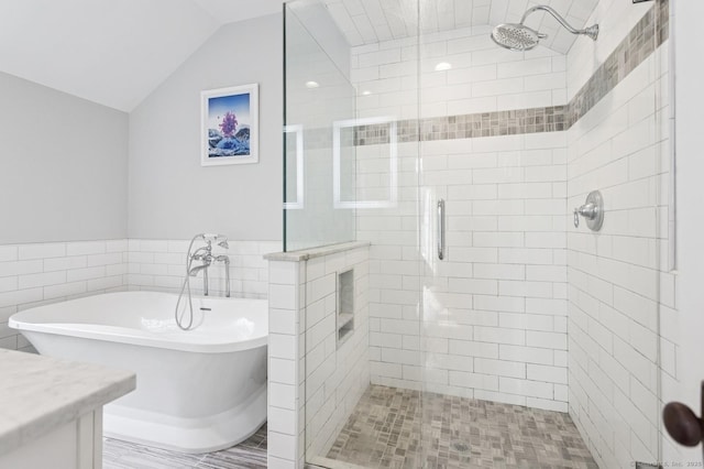 full bathroom with lofted ceiling, a freestanding bath, vanity, and a shower stall