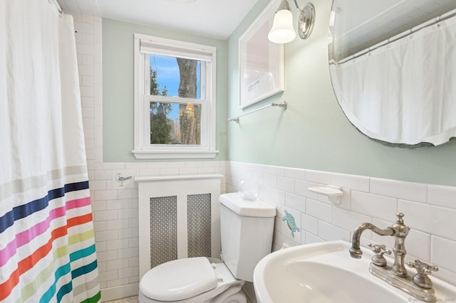 full bath featuring radiator heating unit, a sink, toilet, and tile walls