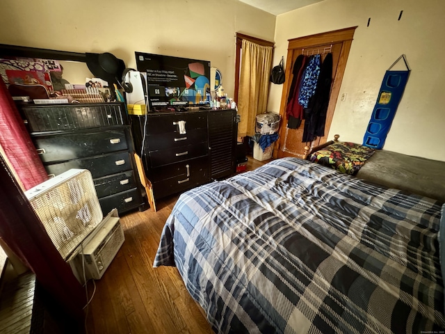 bedroom featuring a closet and dark wood-style flooring