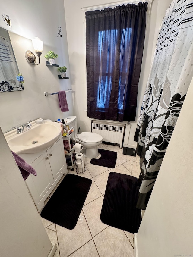 bathroom featuring toilet, radiator heating unit, vanity, and tile patterned floors