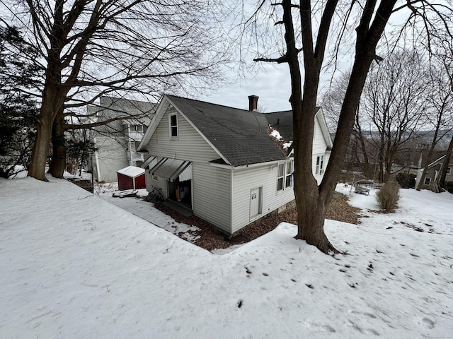 view of snowy exterior featuring a chimney