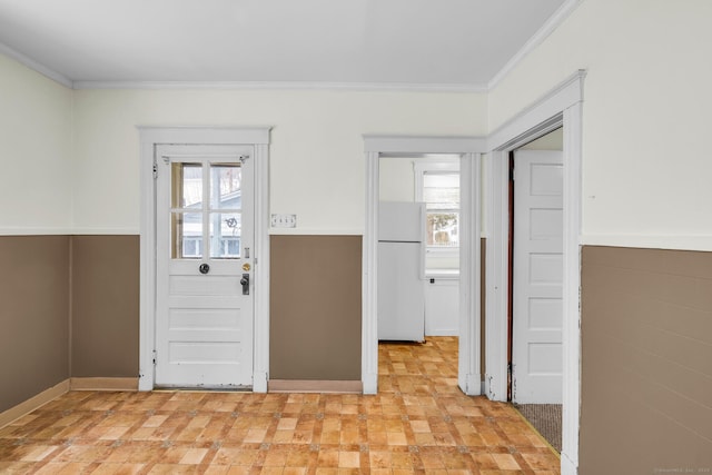 interior space featuring a healthy amount of sunlight, crown molding, and wainscoting