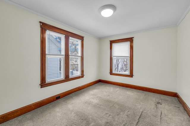 unfurnished room with carpet floors, ornamental molding, and baseboards