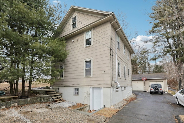 view of side of home with a detached garage and an outdoor structure