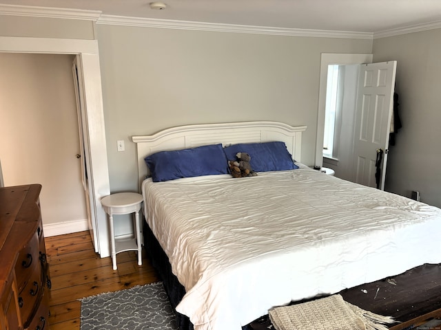 bedroom with wood-type flooring, ornamental molding, and baseboards