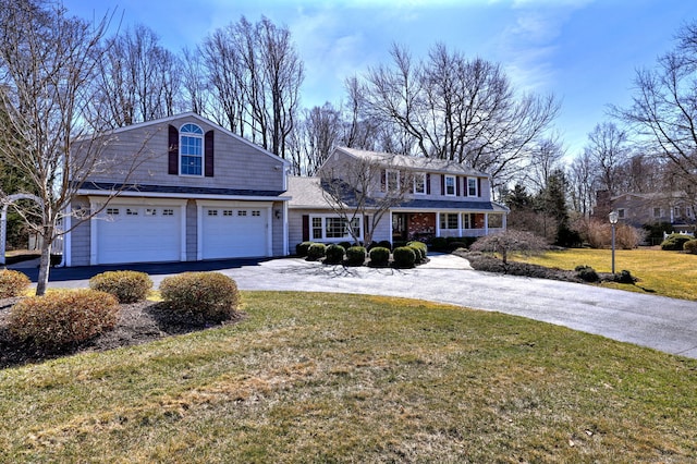 view of front of home featuring aphalt driveway, an attached garage, and a front yard