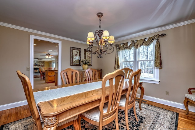 dining room with baseboards, wood finished floors, and ornamental molding