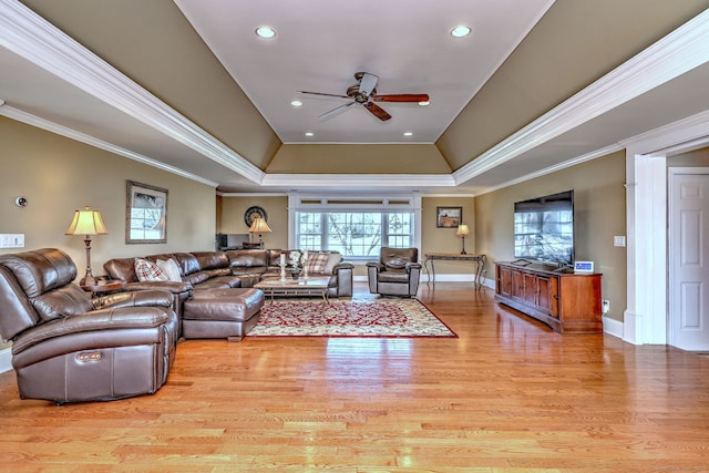 living area featuring recessed lighting, a raised ceiling, light wood-style floors, and ornamental molding