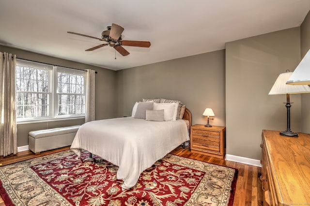 bedroom featuring a ceiling fan, wood finished floors, and baseboards