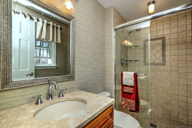 bathroom featuring vanity, tile walls, toilet, and a stall shower