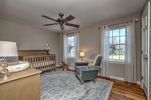 bedroom with multiple windows, baseboards, and wood finished floors