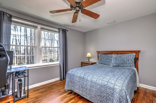 bedroom featuring a ceiling fan, hardwood / wood-style flooring, baseboards, and visible vents