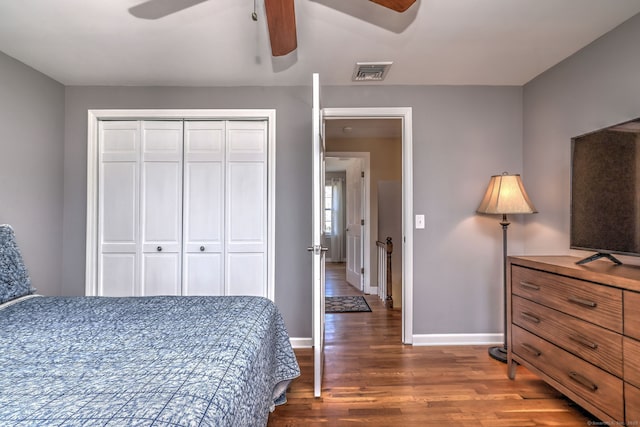 bedroom with visible vents, baseboards, wood finished floors, a closet, and a ceiling fan