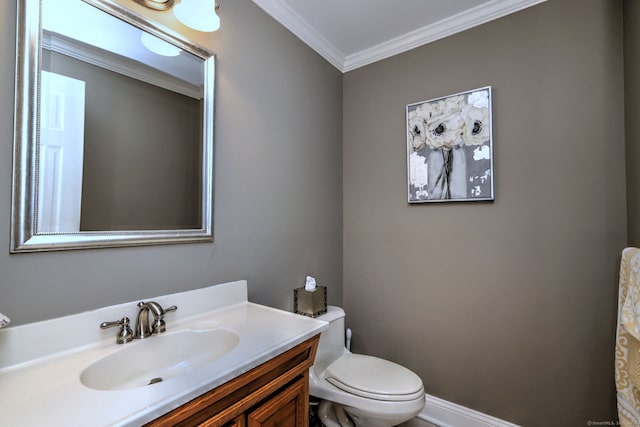 bathroom with vanity, toilet, baseboards, and ornamental molding