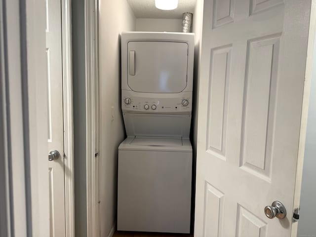 laundry room with stacked washer and clothes dryer and laundry area