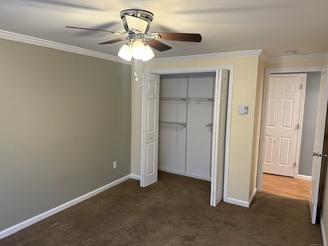 unfurnished bedroom with ornamental molding, a closet, dark carpet, and baseboards