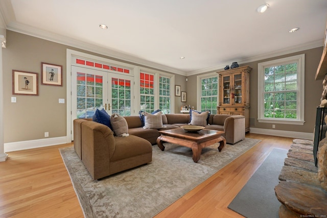 living room with light wood-style floors, baseboards, ornamental molding, and french doors