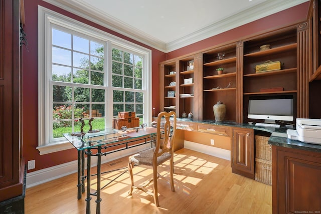 home office featuring baseboards, ornamental molding, built in study area, and light wood-style floors