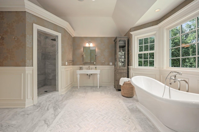 full bath with lofted ceiling, marble finish floor, a wainscoted wall, and a soaking tub