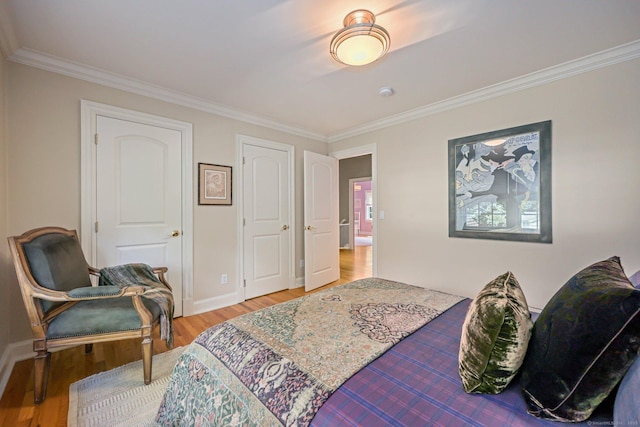 bedroom with baseboards, wood finished floors, and crown molding