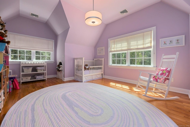 bedroom featuring visible vents, vaulted ceiling, and wood finished floors