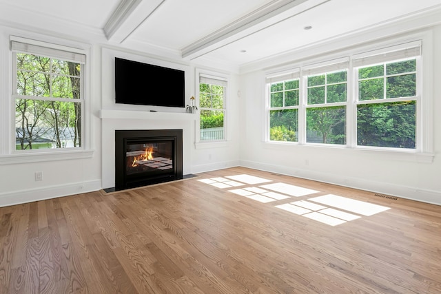 unfurnished living room with plenty of natural light, baseboards, a fireplace with flush hearth, and visible vents
