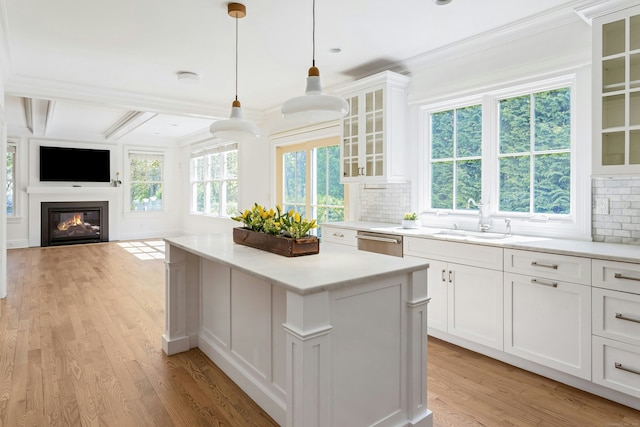 kitchen featuring a center island, tasteful backsplash, a sink, and dishwasher