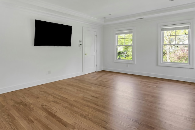 spare room featuring ornamental molding, baseboards, visible vents, and wood finished floors