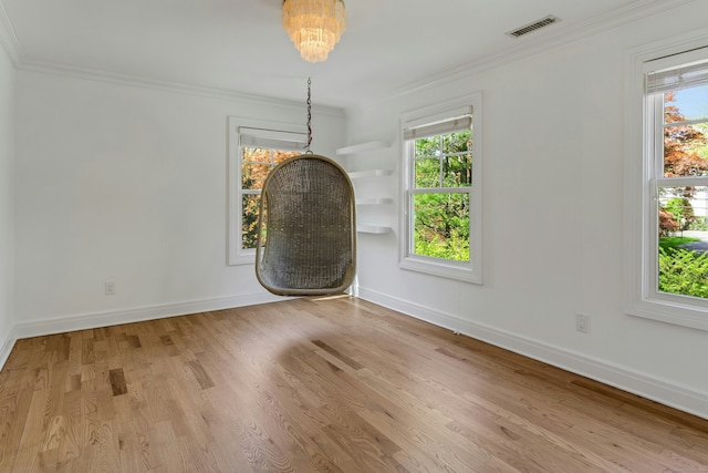 unfurnished dining area with baseboards, crown molding, visible vents, and wood finished floors