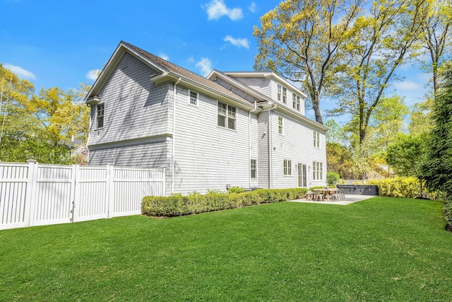 view of side of property featuring a yard, a patio area, and fence