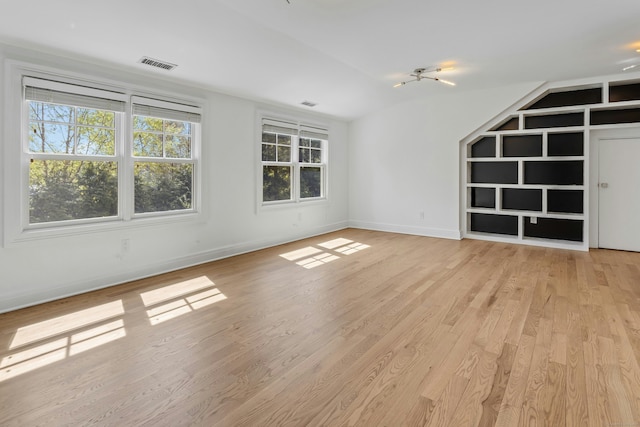 unfurnished living room with light wood-style flooring, baseboards, and visible vents