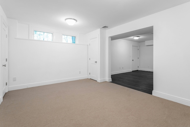 basement featuring carpet, visible vents, and baseboards