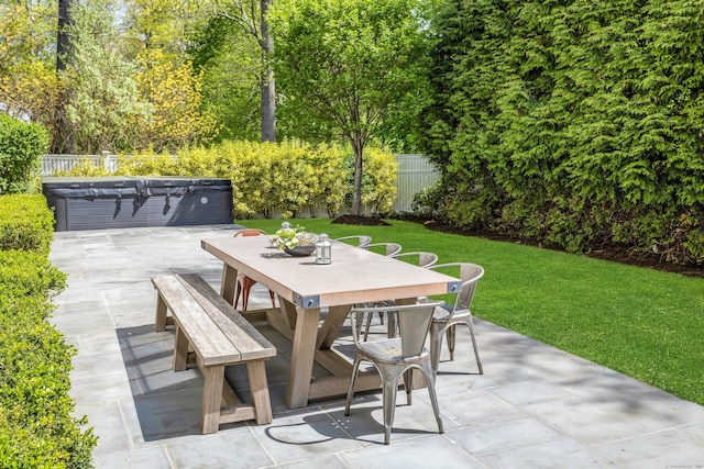 view of patio / terrace featuring outdoor dining space, a hot tub, and fence