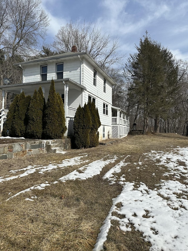 snow covered property with a chimney